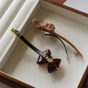 Detail view of acetate tortoise shell bow hair clip and spring metal fastener