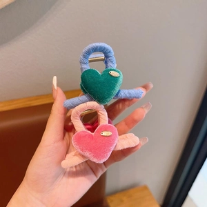 Close-up of velvet heart hair claws for girls in blue and pink with golden details