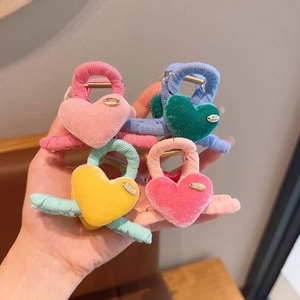Detailed view of four colorful velvet heart hair claws with golden handmade tags
