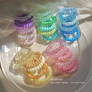 Élastiques à cheveux en spirale dégradés colorés présentés sur une assiette en céramique