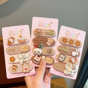 Close-up of 12 pieces of cartoon embroidered hair clips with bears and bows on cards