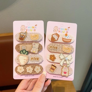 Close-up of cute coffee-colored embroidered hair clips featuring teddy bears and bows