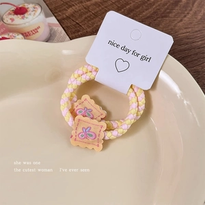 Detail of sweet woven hair ties with biscuit embroidery on a white display card
