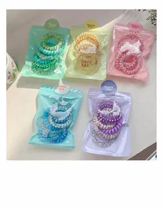 Détail de cinq packs d'élastiques spirales en couleurs pastel avec autocollants de merci