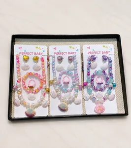 Detail of colorful mermaid tail jewelry set with pearl beads and shell pendants