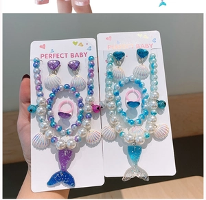 Detail of colorful mermaid tail jewelry set with pearl beads and shell pendants