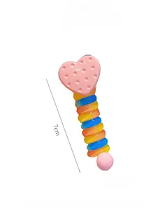 Detail showing a 7cm colorful spiral resin hair coil with a pink heart charm