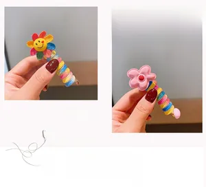 Detail of spiral telephone wire hair tie with colorful sunflower and pink floral ornaments