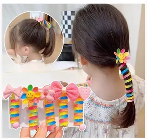Detail of colorful spiral hair ties featuring sunflower and heart charms for kids