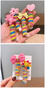 Detailed view of colorful spiral hair ties with pink bear, flower, and bow charms