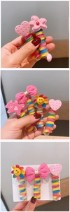 Close-up of candy-colored spiral hair ties featuring cute heart and sunflower charms