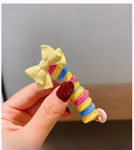 Detailed macro view of colorful spiral hair tie with a cute yellow resin bow decoration