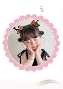 Close-up of children's Halloween reindeer horn hair clips with pumpkin glitter motifs
