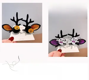Detail view of Halloween antler hair clips featuring small pumpkin and ghost decorations