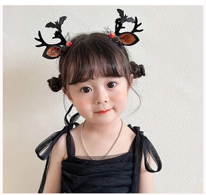 Detail of Halloween antler headband with glitter orange ears and bat wings on a child