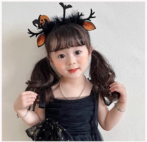 Close-up of Halloween headband featuring black antlers, orange ears, and pumpkin accents