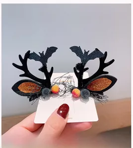Detail of Halloween antler hair clips with black bats, glitter, and colorful pom-poms