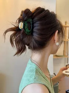 Elegant dark green marble acetic acid hair claw clip shown on a female model with pearls