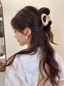 Detail of pink and beige marble texture hair claw clip in a half-up hairstyle