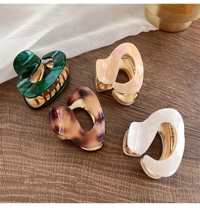 Close-up of acetic acid hair claws in four colors with durable gold metal teeth detail