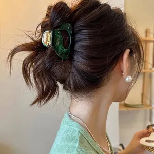 Elegant marble green acetate hair claw clip for bun hairstyles on a female model