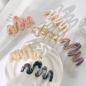 Détail de six pinces à cheveux ondulées avec des motifs marbrés en plusieurs coloris