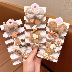 Detail of cute flower hair ties set in cream coffee colors for girls ponytails