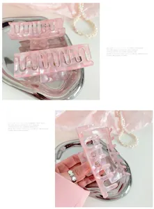 Detail of pink marble acetate hair claw clip with rectangular hollow design and smooth teeth