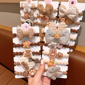 Detailed close-up of coffee-toned hair ties featuring knit bows and cute bear charms