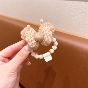 Detail of plush butterfly hair scrunchie with knit center and two elegant white pearls