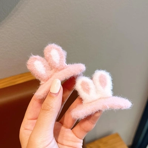 Close-up of cute pink plush bunny ear hair clips with soft fuzzy texture for girls