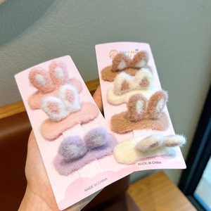 Plush 3D bunny ear hair clips for kids in various soft colors on display card