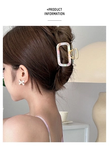 Close-up of marble acetate square hair claw and crystal bow earring in daily lifestyle setting