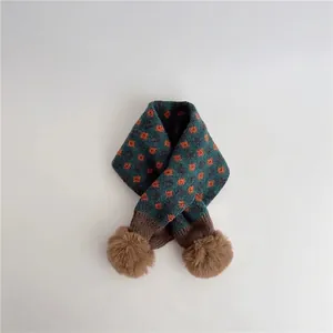 Close-up of knit scarf texture with vintage floral patterns and soft plush pom-poms