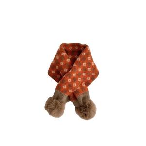 Winter baby knitted scarf with orange checkerboard pattern and brown plush pom-poms