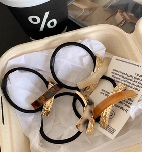 Close-up of premium acetate hair ties with gold metal hardware in various colors