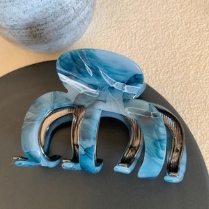 Detail view of blue marble acetate hair claw clip with strong silver metal teeth