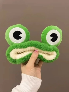 Gros plan détaillé du tissu en peluche vert et des yeux de grenouille sur le bandeau