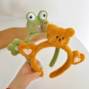 Dettaglio di cerchietti di peluche a forma di rana e orso con morbida texture in flanella