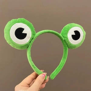 Détail du bandeau yeux de grenouille en peluche verte pour le lavage du visage et le style