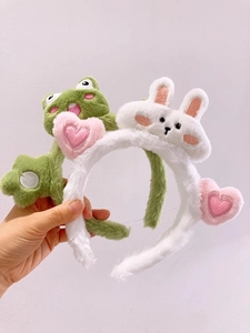 Dettaglio set cerchietti in peluche con rana verde e coniglio bianco in tessuto morbido