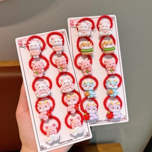 Close-up of festive red elastic hair ties with 3D cartoon dragon charms for girls