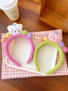 Detaillierte Nahaufnahme süßer Plüsch-Teddybär-Stirnbänder in Rosa und Grün
