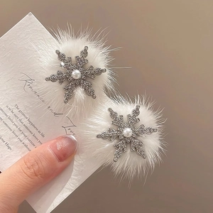 Detail von Schneeflocken Haarspangen mit weißen Plüschkugeln und Perlen auf einer Karte
