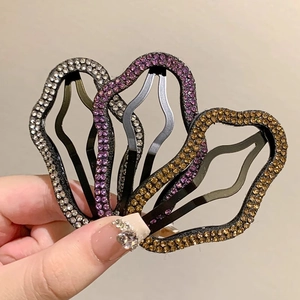 Tre fermagli per capelli ondulati con strass in argento, viola e oro su metallo nero