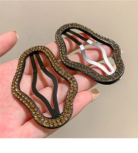 Dettaglio di fermagli per capelli a forma di nuvola con strass ambrati e base nera
