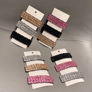 Detailansicht von vier Sets funkelnder Strass-Haarspangen in verschiedenen Farben