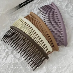 Vue détaillée de quatre peignes à cheveux mats aux couleurs Morandi sur papier blanc