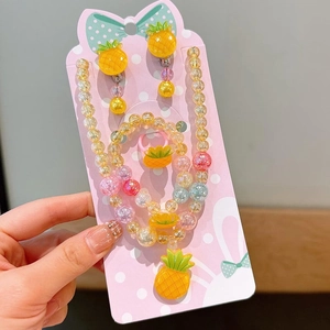 Detail eines Mädchen-Perlenschmuck-Sets mit gelben Ananas-Anhängern aus Kunstharz