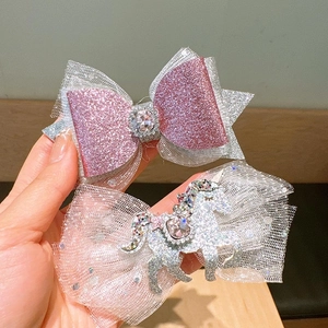 Detail of pink sequin bow and unicorn hair clips with glitter rhinestones for girls